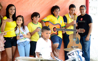 Children line up, one with a guitar